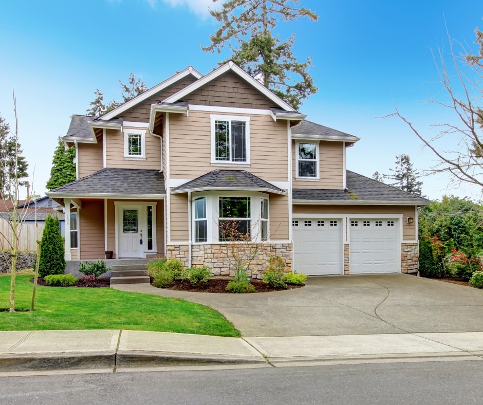 A large house with two stories and a garage. The house has a covered porch.