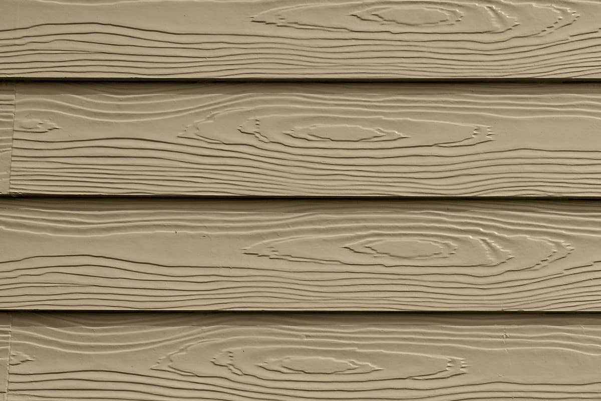 Brown wooden siding with a wood grain pattern. Horizontal panels with a natural look.